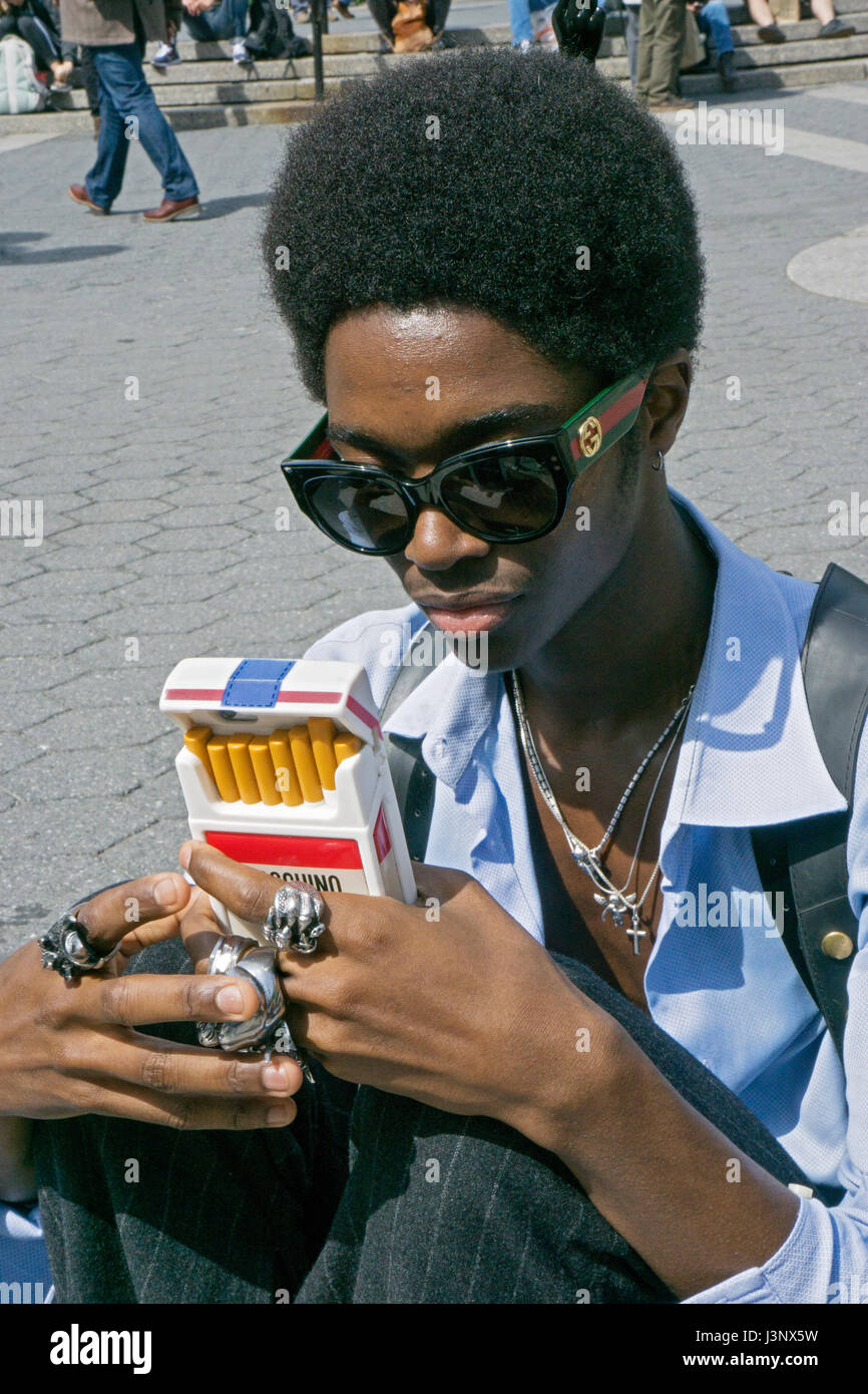 Porträt eines jungen Mannes mit einem ungewöhnlichen Handy Gehäuse gestellt. Union Square Park in Downtown Manhattan, New York City aufgenommen. Stockfoto