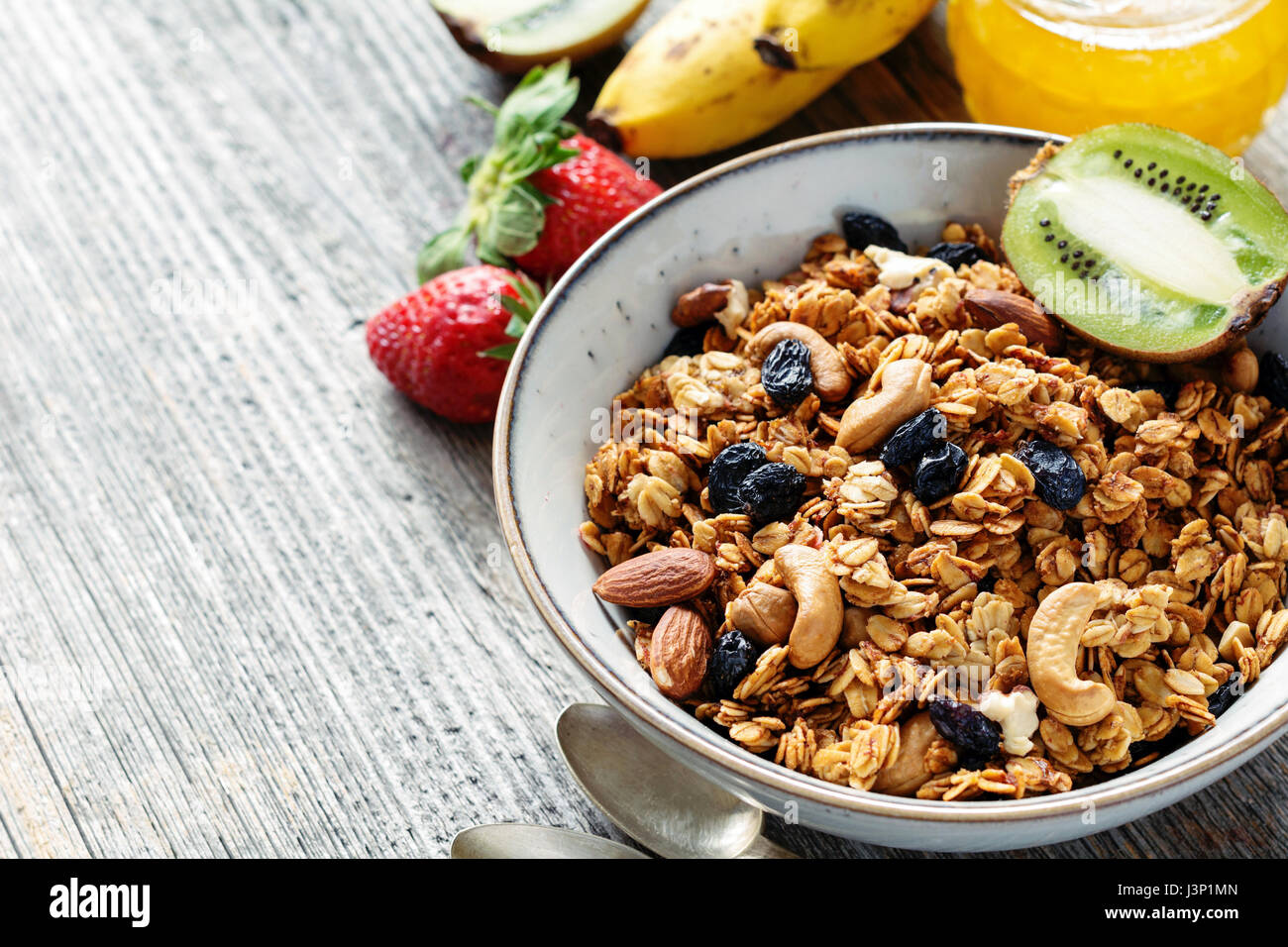 Gesundes Frühstück Essen: Schüssel Müsli Müsli, Obst und Honig auf Holztisch. Nahaufnahme, Kopie spac Stockfoto