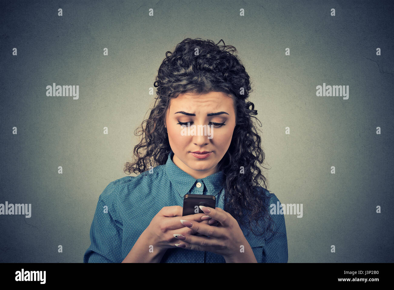 Closeup Portrait verärgert traurig unglücklich Ernst Frau Gespräch SMS auf Handy unzufrieden mit Gespräch auf grauem Hintergrund isoliert. Negativen hu Stockfoto