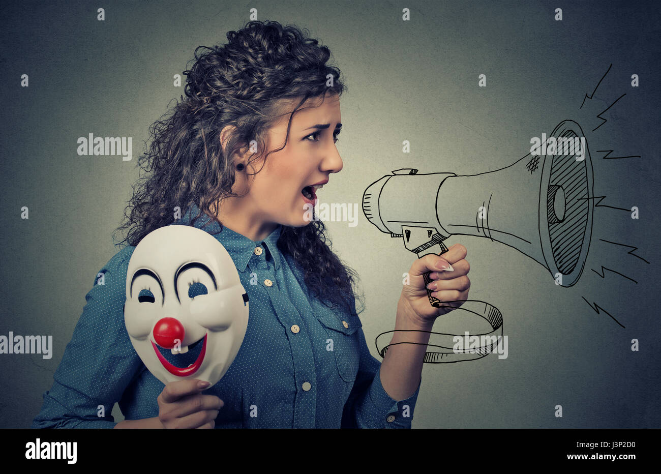 Frau mit Megaphon und Clown Maske schreien Stockfoto