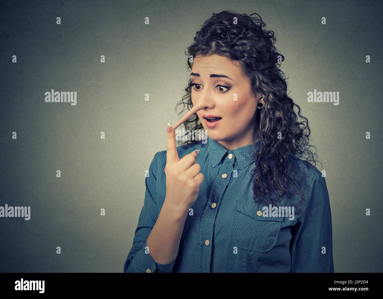 Frau mit langen Nase auf graue Wand Hintergrund isoliert. Lügner-Konzept. Menschlichen Gesichtsausdruck, Emotionen, Gefühle. Stockfoto