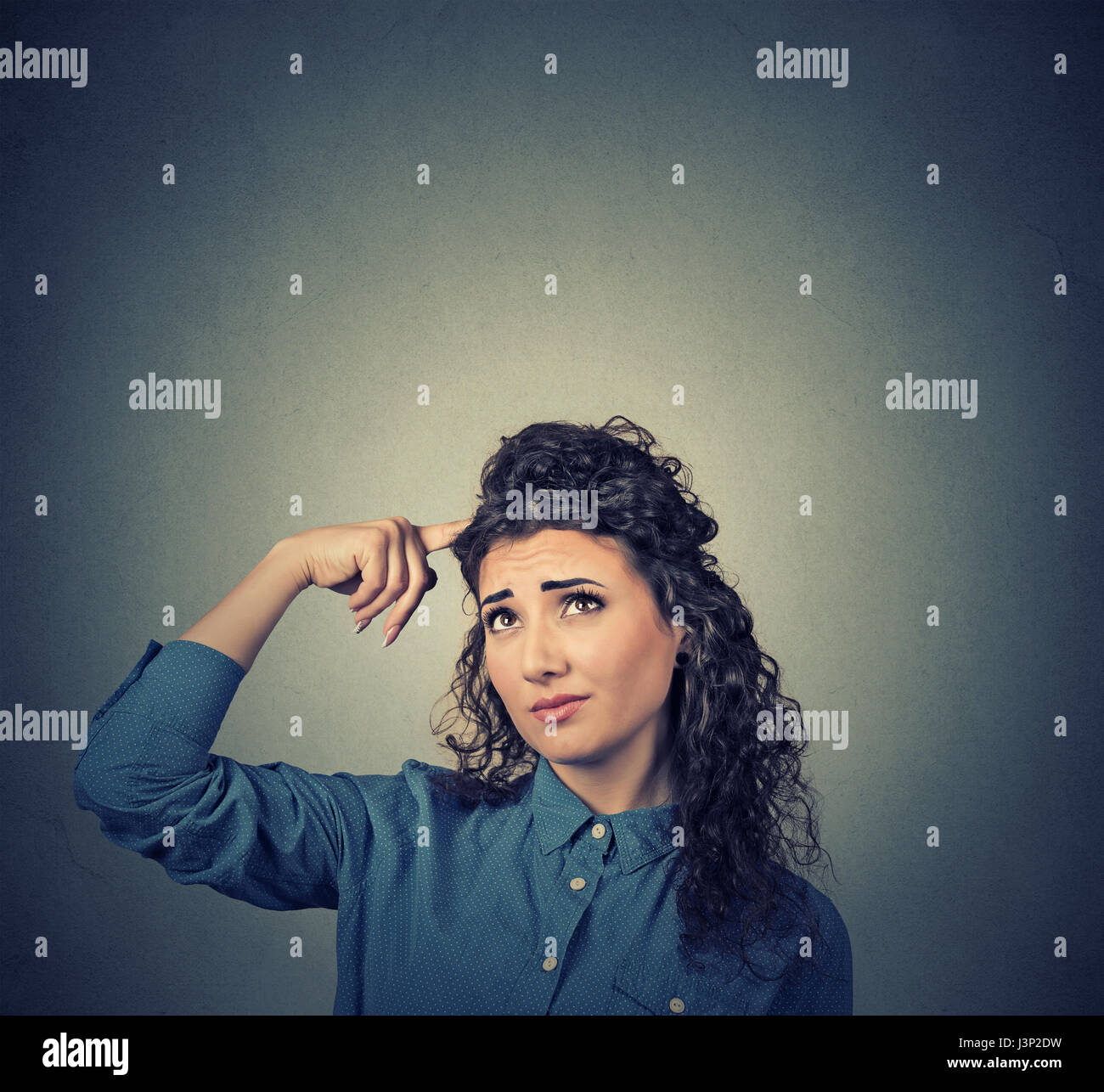 Porträt Closeup verwirrt skeptisch junge Frau auszudenken suchen isoliert auf grauem Hintergrund Kopie Wandfläche über Kopf. Menschliche Ausdrucksformen, emotion Stockfoto