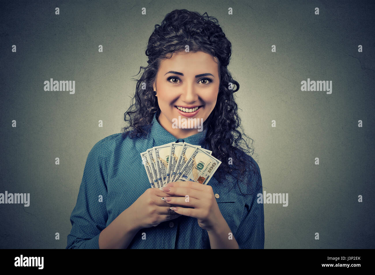 Closeup Portrait glücklich aufgeregt erfolgreiche junge Geschäftsfrau halten Geld Dollar-Scheine in der hand auf graue Wand Hintergrund isoliert. Positive Emotionen f Stockfoto