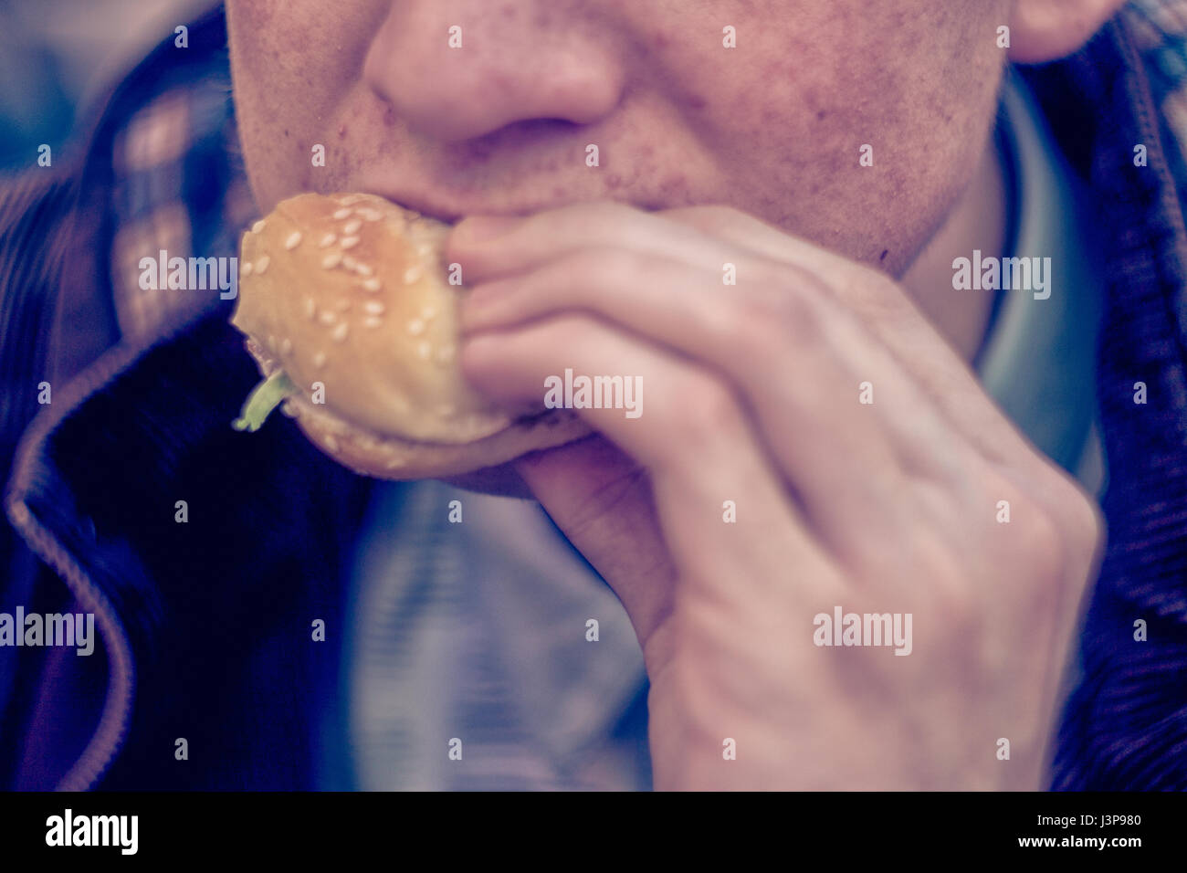 Kursk, Russland - 24. April 2017: Junger Mann Essen Burger in Fast-food Stockfoto