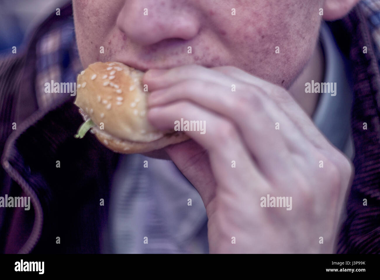 Kursk, Russland - 24. April 2017: Junger Mann Essen Burger in Fast-food Stockfoto