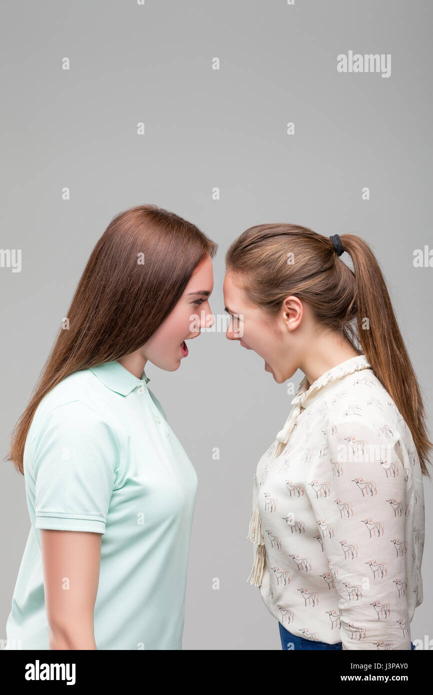 Zwei Mädchen schreien sich gegenseitig, Studio Fotoshooting. Frauen-Streit Stockfoto