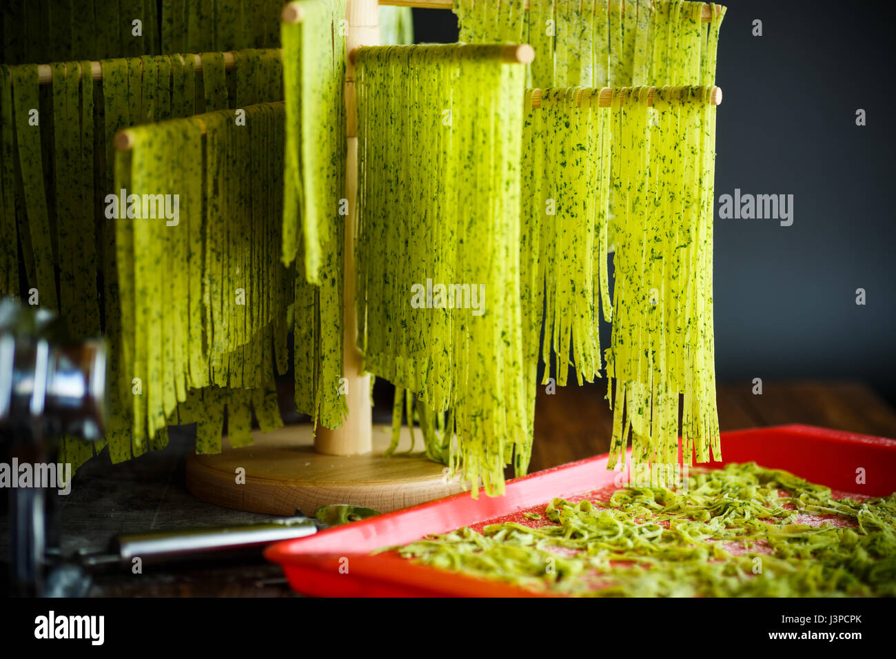 Hausgemachte Nudeln grün mit Grüns auf einem Holztisch Stockfoto