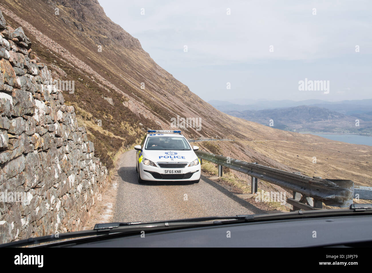 Polizeiauto fahren über Bealach Na Ba Applecross Pass Richtung Applecross, Scotland, UK Stockfoto