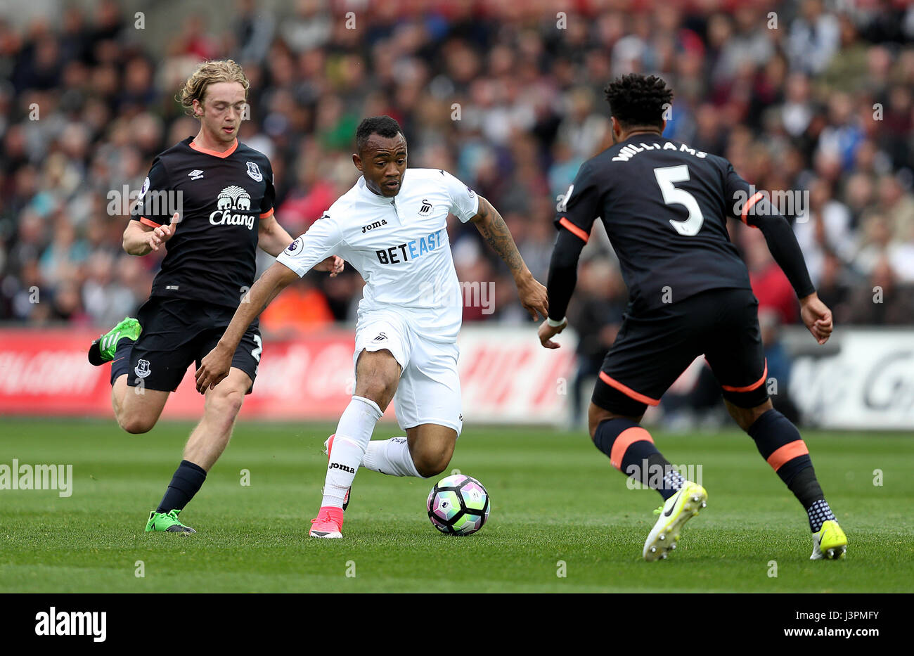 Swansea City Jordan Ayew (Mitte) und Everton Ashley Williams Kampf um den Ball in der Premier League match bei der Liberty Stadium, Swansea. Stockfoto