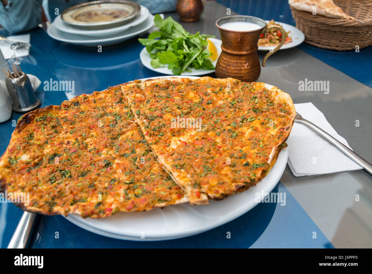Lahmacun (Turksih Pizza) auf der Talbe mit Ayran und grrenery Stockfoto