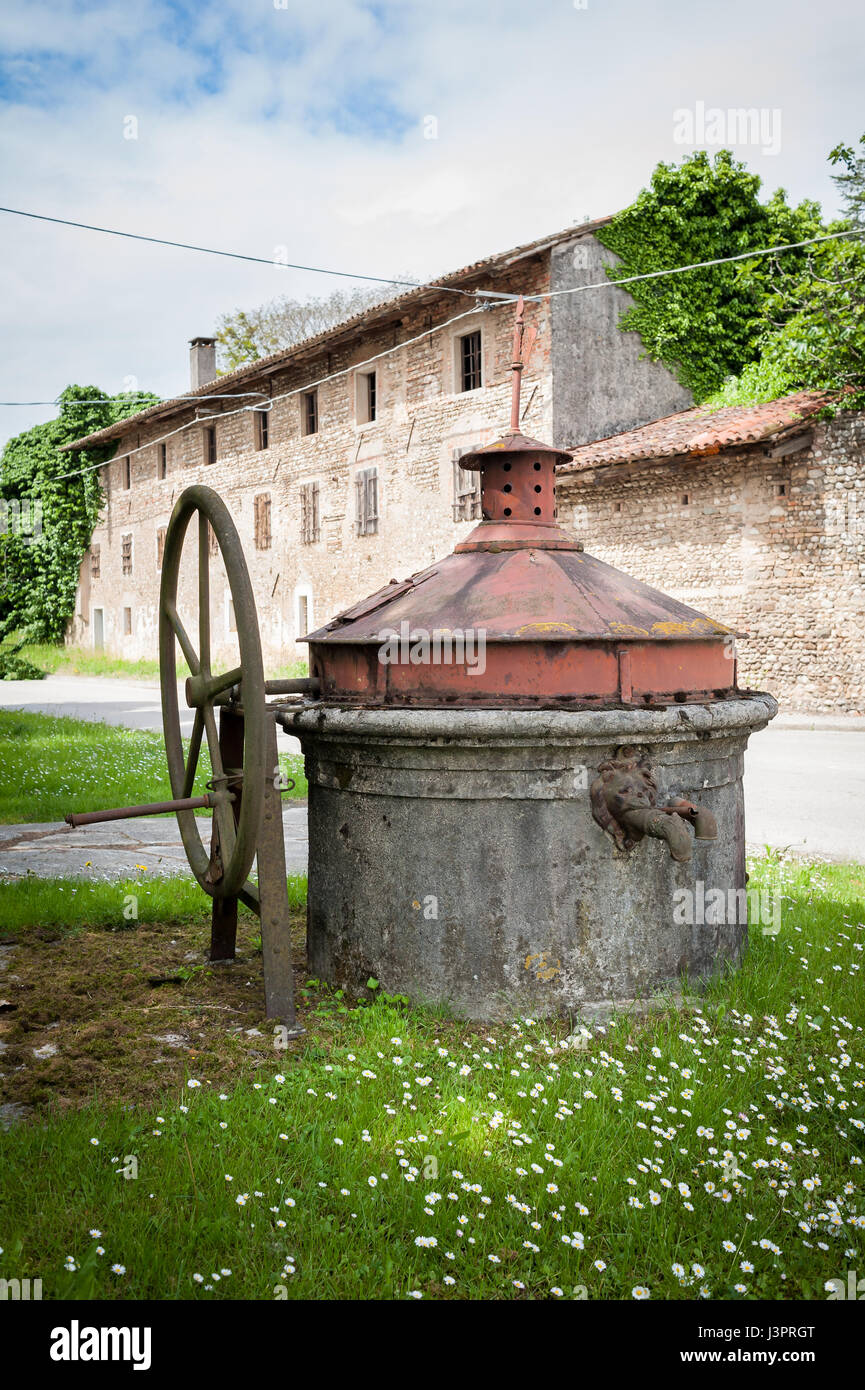 Alte gut abgedeckt mit Handpumpe. Es benötigt um das Land. Stockfoto