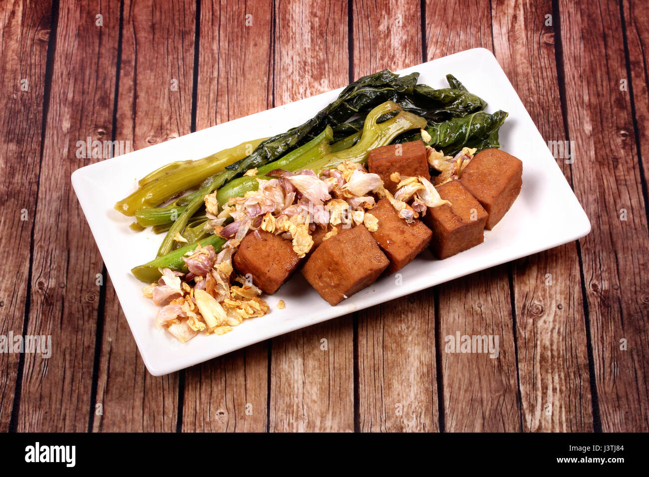 Gebratener Kohl mit Tofu in braune Suppe gekrönt knusprigen Knoblauch, kein Fleisch. Stockfoto