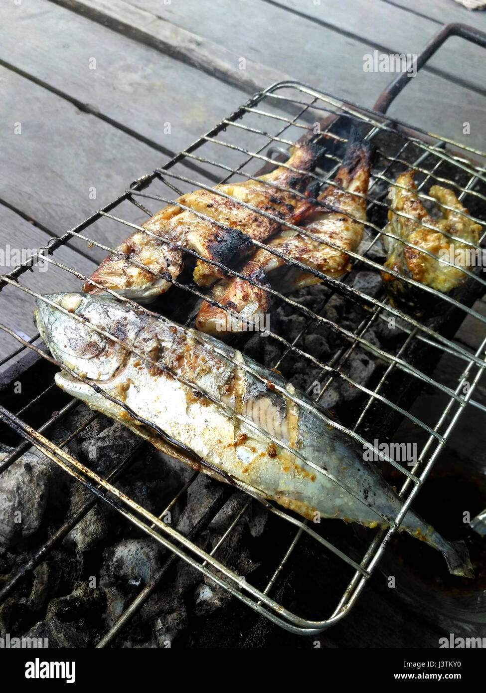 Der Prozess der Verbrennung von Fisch auf einem Kohlegrill Stockfoto