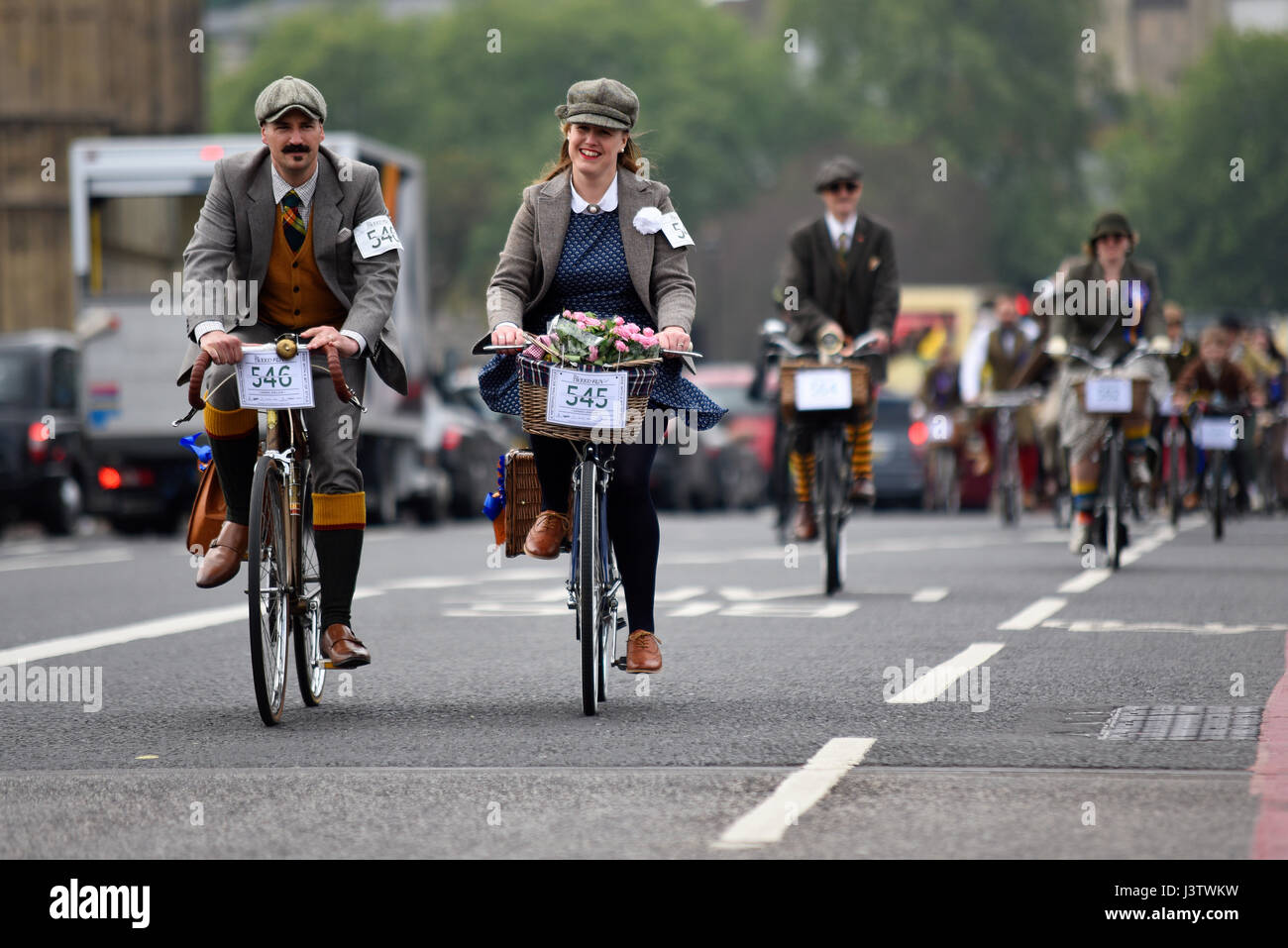 Tweed Run Radfahrer in London überqueren die Westminster Bridge und passieren die Houses of Parliament Stockfoto