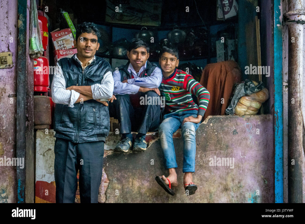 Die Familie sitzt außerhalb des Lagerbereichs in Delhi, Indien und sieht zufrieden aus Stockfoto