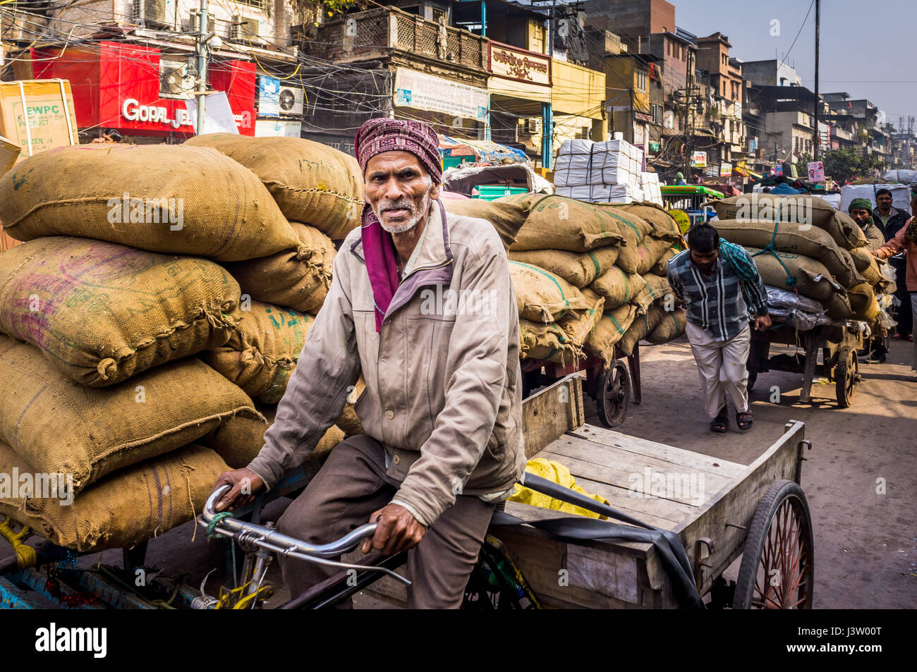 Straßenszene in Delhi, Indien zeigen die Träger nehmen die Ware auf dem Markt und das Chaos verursacht es Stockfoto