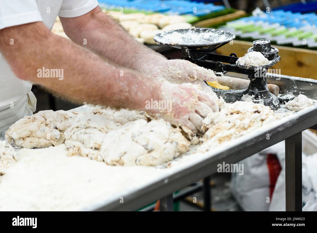 Ein Bäcker wiegt Teile aus Teig, wie er Irish Soda Farls Brot macht. Stockfoto