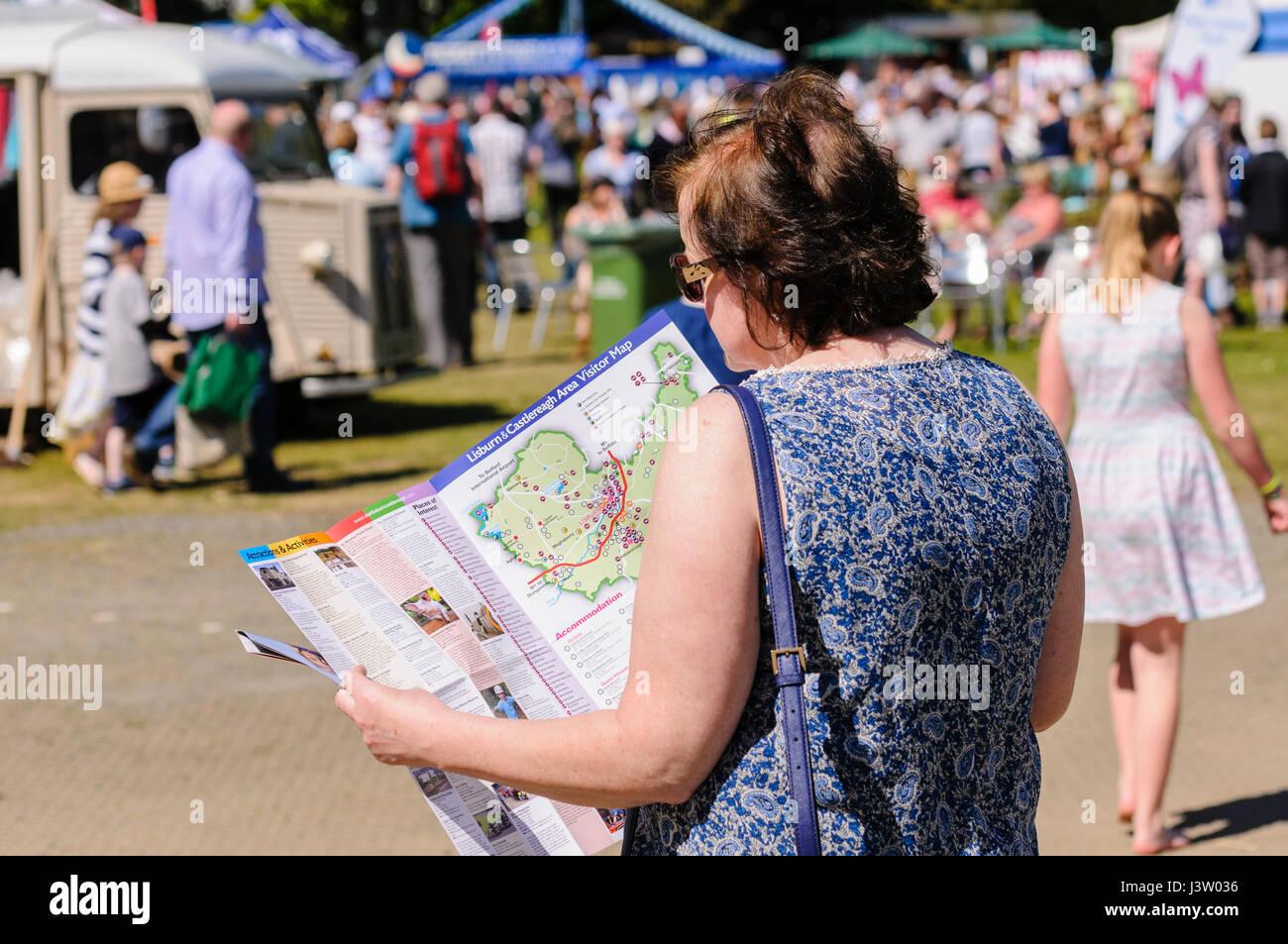 Eine Frau schaut auf eine Karte, um ihre Orientierung auf ein outdoor-event Stockfoto
