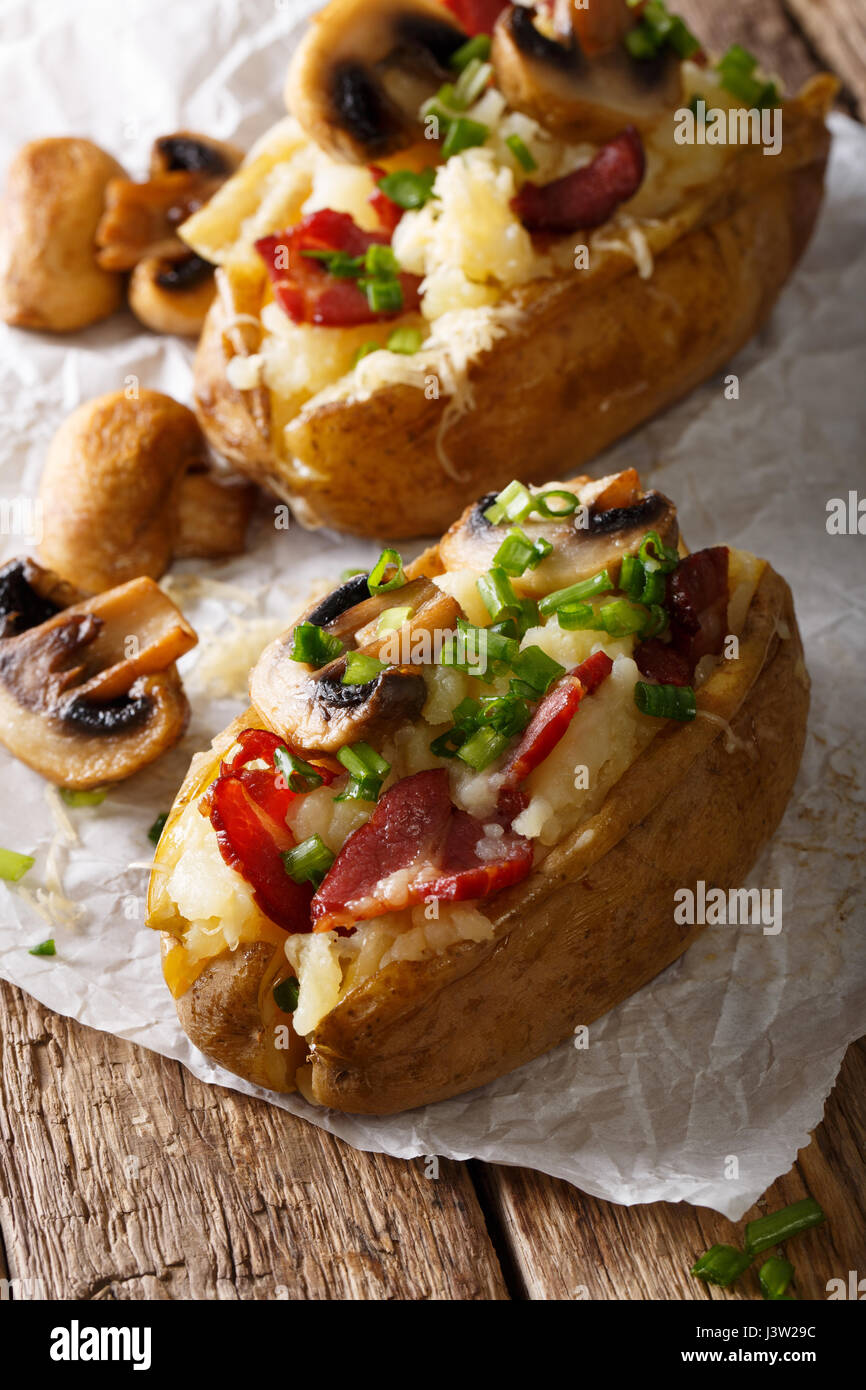 Ofenkartoffel gefüllt mit Speck, Champignons und Käse-close-up auf dem ...