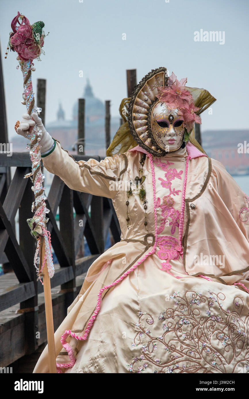 Bild einer Person in einem bunten Kostüm entlang des Canal Grande während des Carnevale-Festivals in Venedig, Italien. Stockfoto