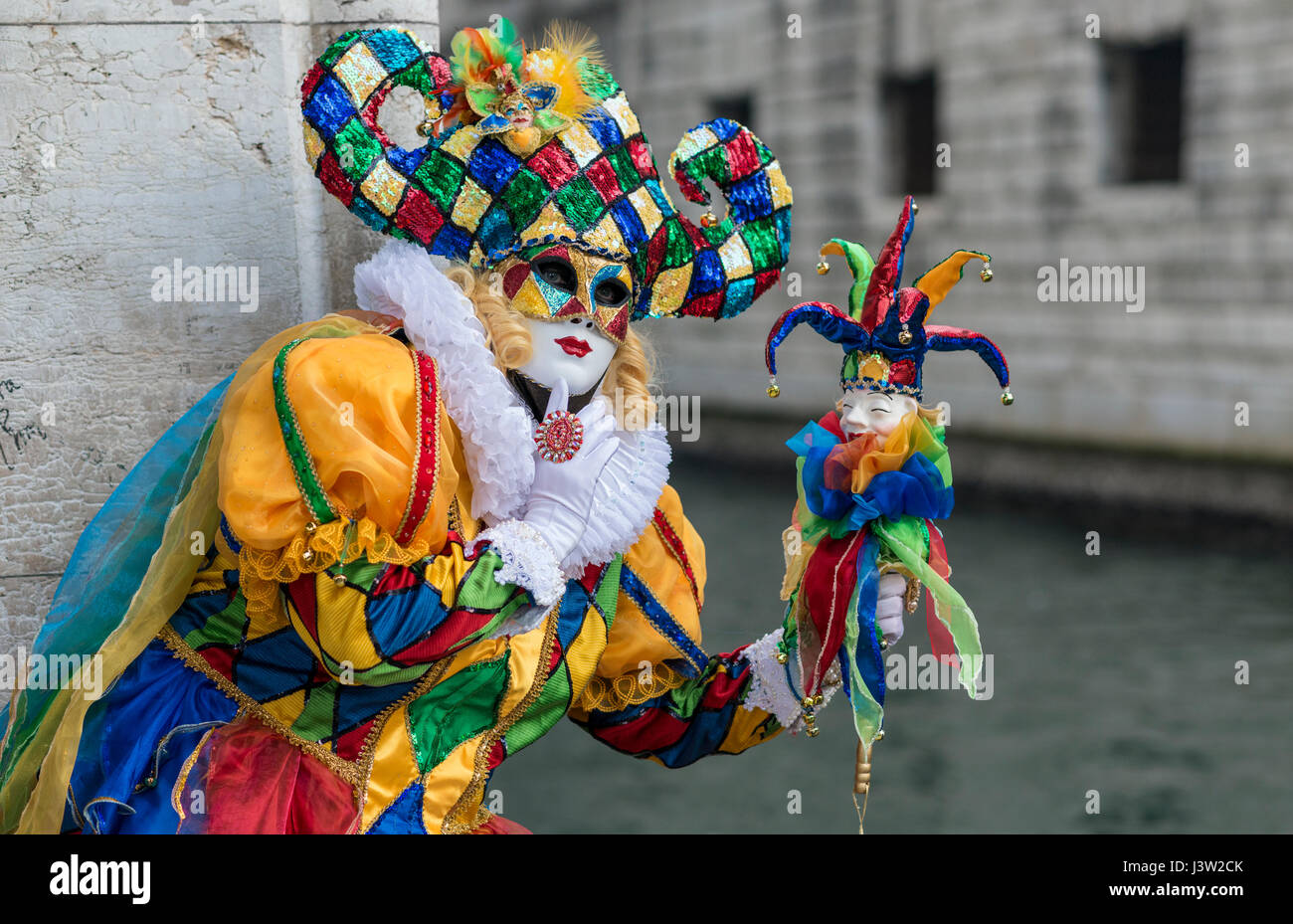 Bild eines Individuums in einem bunten Kostüm außerhalb des Dogenpalastes während des Carnevale Festivals in Venedig, Italien. Stockfoto