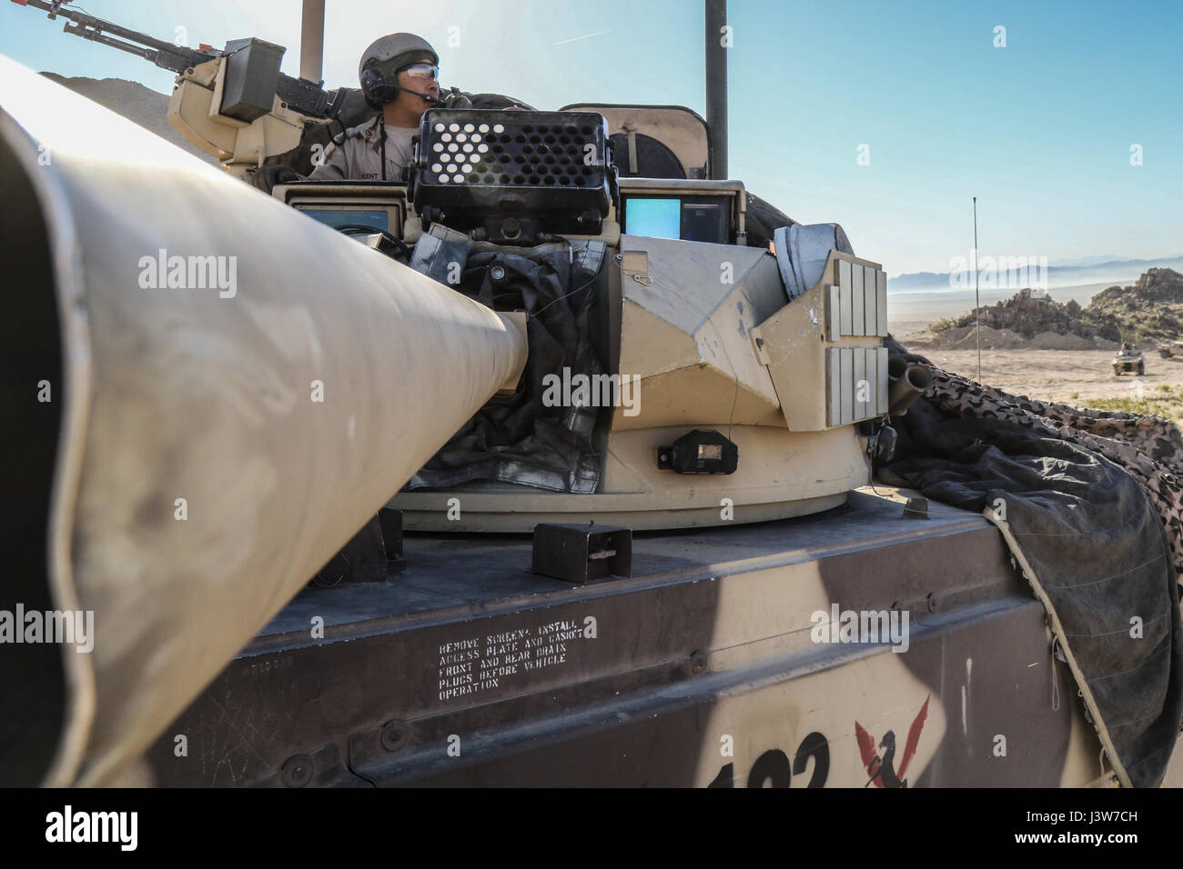 FORT IRWIN, Kalifornien – A Trooper von Coldsteel Truppe, 1. Staffel, 11th Armored Cavalry Regiment, scannt das Schlachtfeld von einer Main Battle Tank während ihres Angriffs gegen Elemente der 2. gepanzerte Brigade Combat Team, 1st Infantry Division, in der Nähe der National Training Center Eisernen Dreieck, 2. Mai 2017 der Zweck dieser Phase der NTC Rotation 17-06, herausgefordert der Dagger Brigade Fähigkeit zur Durchführung einer Verteidigung gegen einen Gegner in der Nähe von Peer in Verbindung mit einer großflächigen Sicherheitsbedrohung. (US Armee-Foto von Pfc. Austin Anyzeski, 11th ACR) Stockfoto