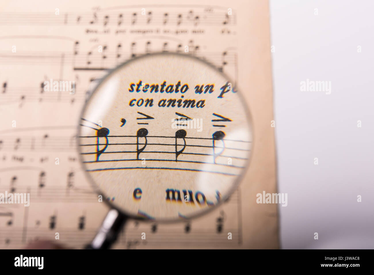 ein Blick auf die Noten in eine Partitur mit Lupe Stockfoto