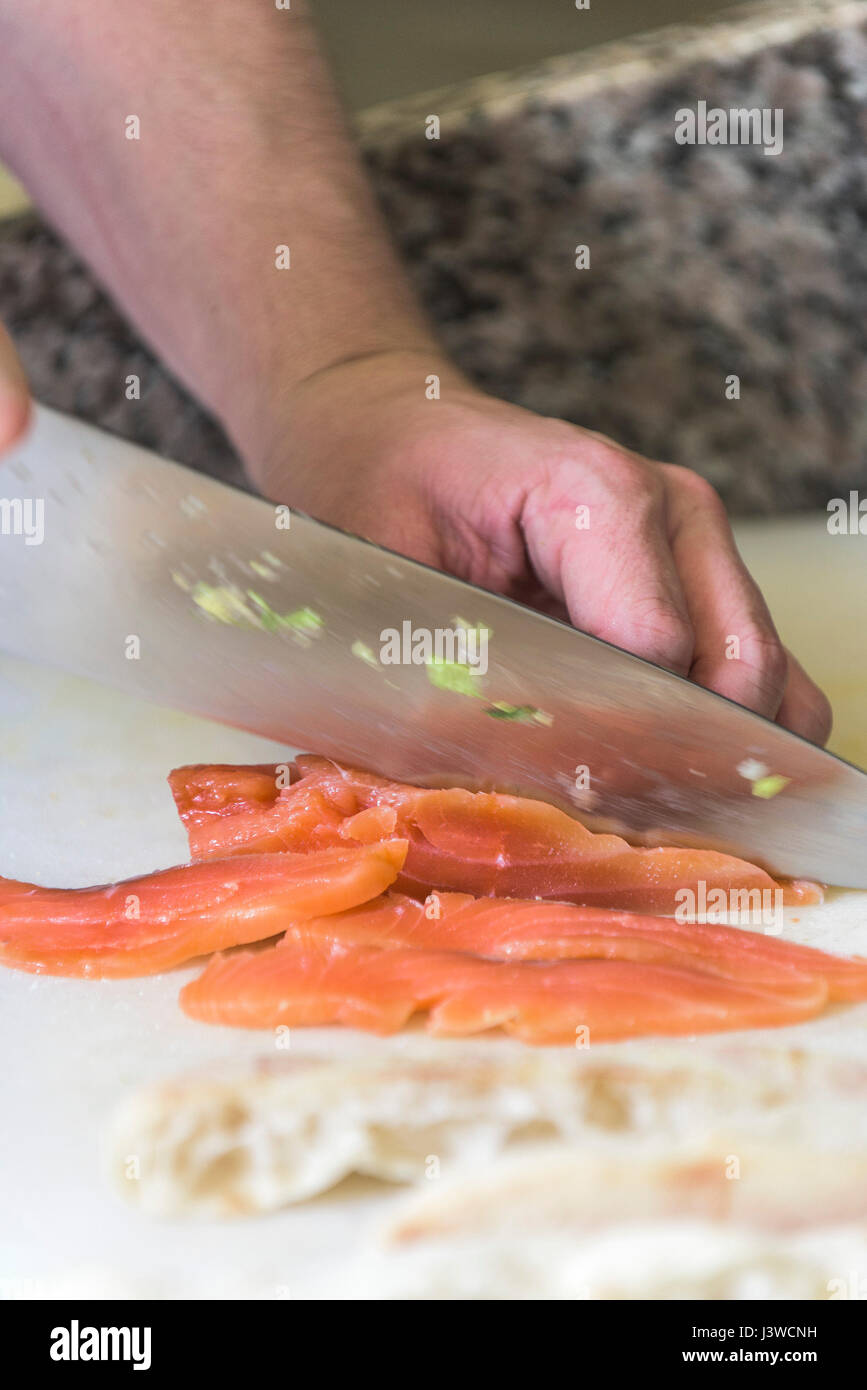 Ein Koch schneiden geräucherter Lachs Messer Küche Essen Vorbereitung Fischgericht Essen Lebensmittel-Industrie Stockfoto