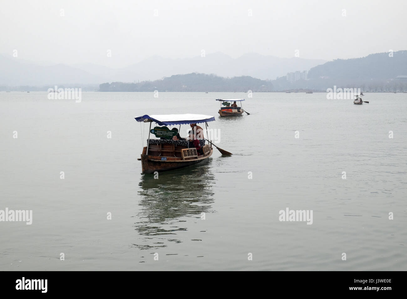 Menschen ziehen in Booten am Westsee in Hangzhou, China, 21. Februar 2016. Stockfoto