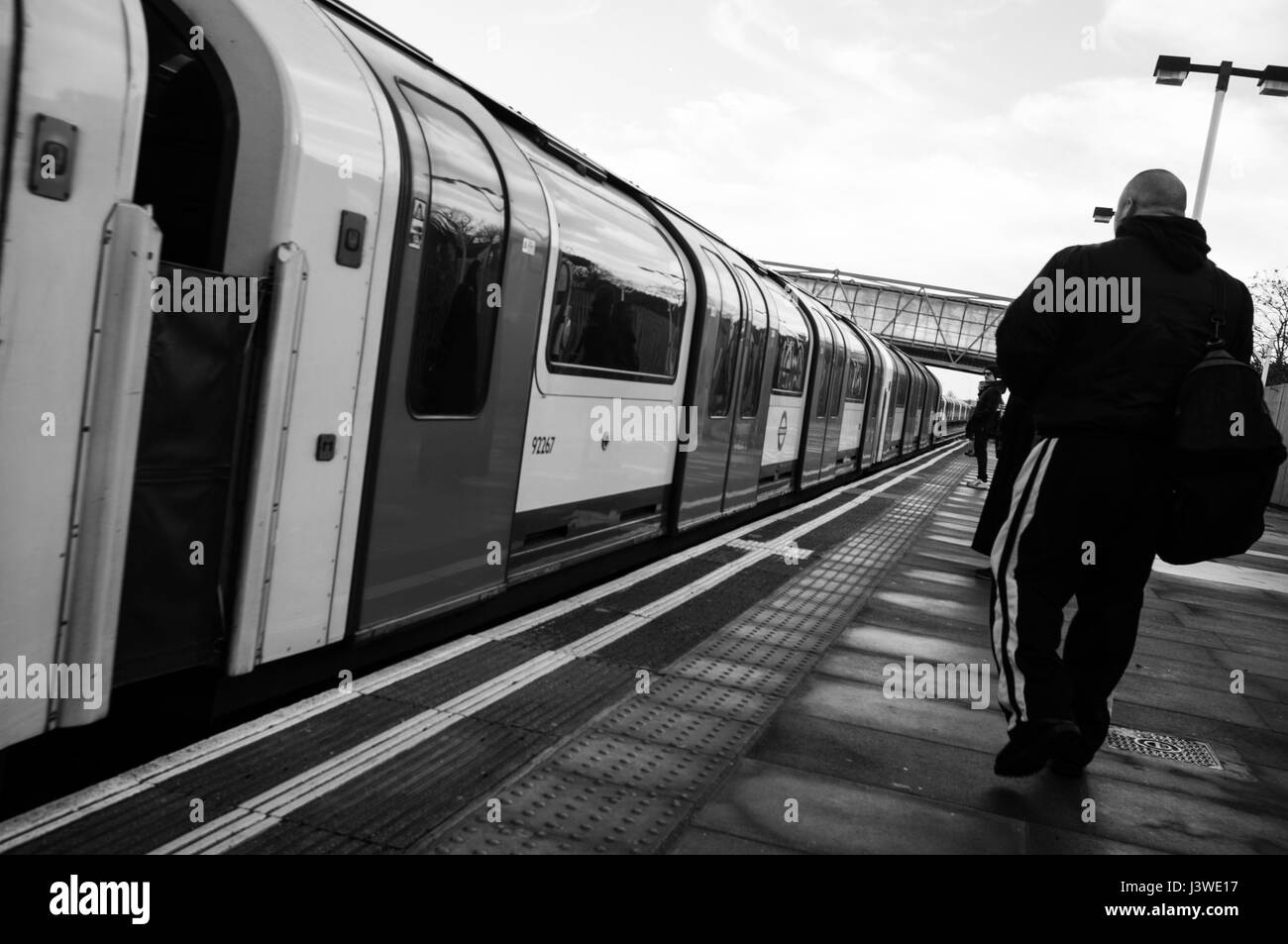 Mann auf Plattform neben Central Line Zug in Leytonstone Station. Stockfoto