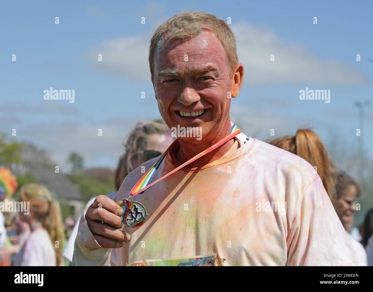 Liberal Democrats Tim Farron mit seiner Medaille nach Abschluss der jährlichen Kendal Farbe Strich, ein 5km Spaß laufen zugunsten Hospiz St. Johns Kirkbie Kendal Schule in Kendal, Cumbria. Stockfoto