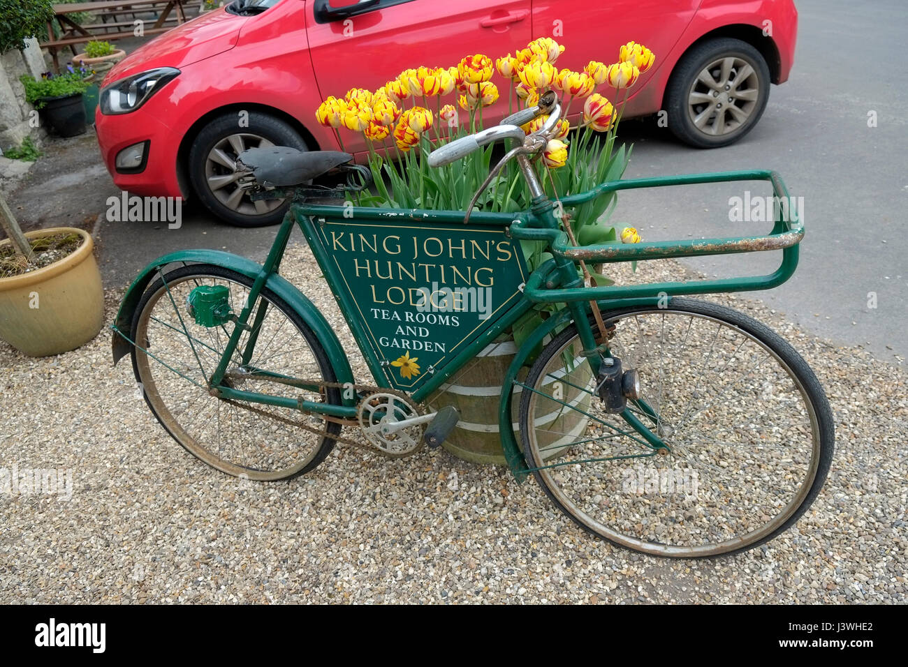 Ein altes Fahrrad verwendet eine Werbung für die König-Johann Jagdschloss Tee Zimmer in Lacock, Wiltshire, UK. Stockfoto
