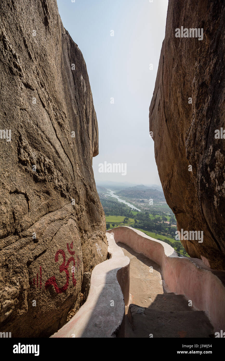 Hampi Dorf gesehen durch große Felsblöcke, Aussicht von Anjaneya Hügeln, Hampi. Stockfoto