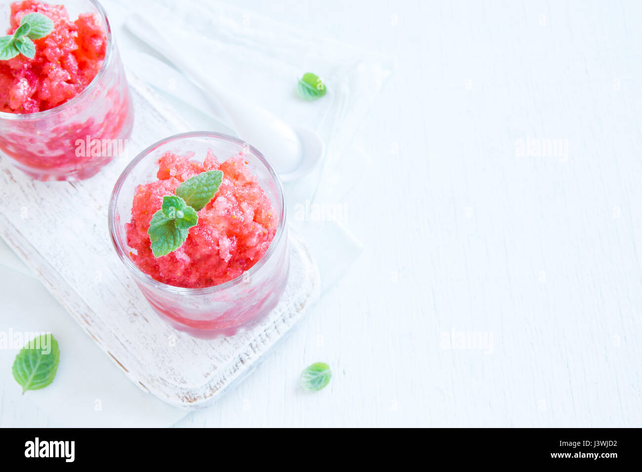 Erdbeer-Granita mit Minze (gefrorene Dessert) in Teil Gläser auf weißem Hintergrund mit Textfreiraum Stockfoto