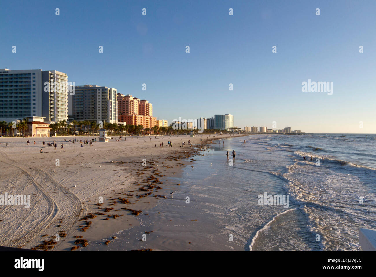 Clearwater, Florida - 24. Januar 2017: Am späten Nachmittag bei klarem Wasser Strand gesäumt von bunten Gebäuden und Wellen Washig auf Sand und fernen p Stockfoto