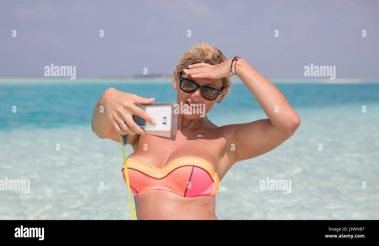Hübsche Frau macht selfie am Strand Stockfoto