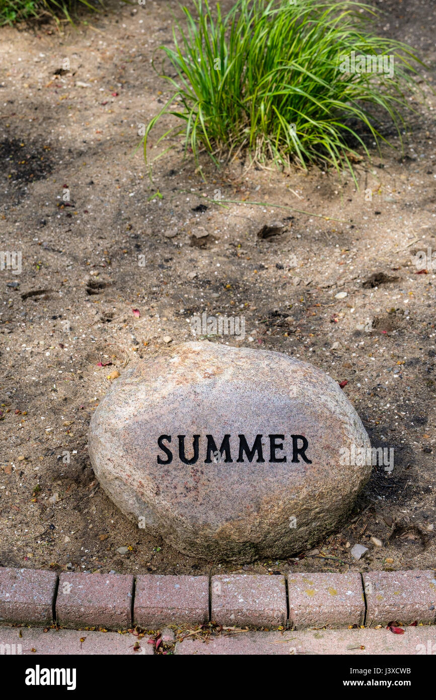 Wort Sommer geschrieben, Sommer Gravur, Prägung, auf einem dekorativen Garten Stein, Jahreszeiten des Jahres, Dekoration, Gartenstein, dekorativen Stein Zeichen. Stockfoto