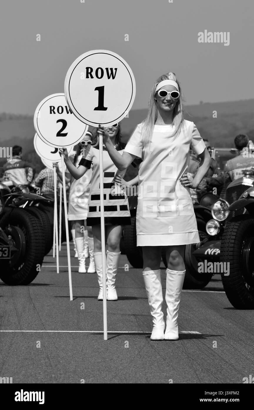 Monochromes Bild der Grid Girls beim Benjafields Racing Club Sprint auf dem Goodwood Motor Circuit in West Sussex, England. Stockfoto