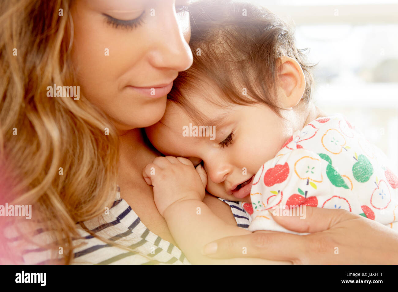 Müde Mädchen mit Kopf auf Mutters Schultern Stockfoto