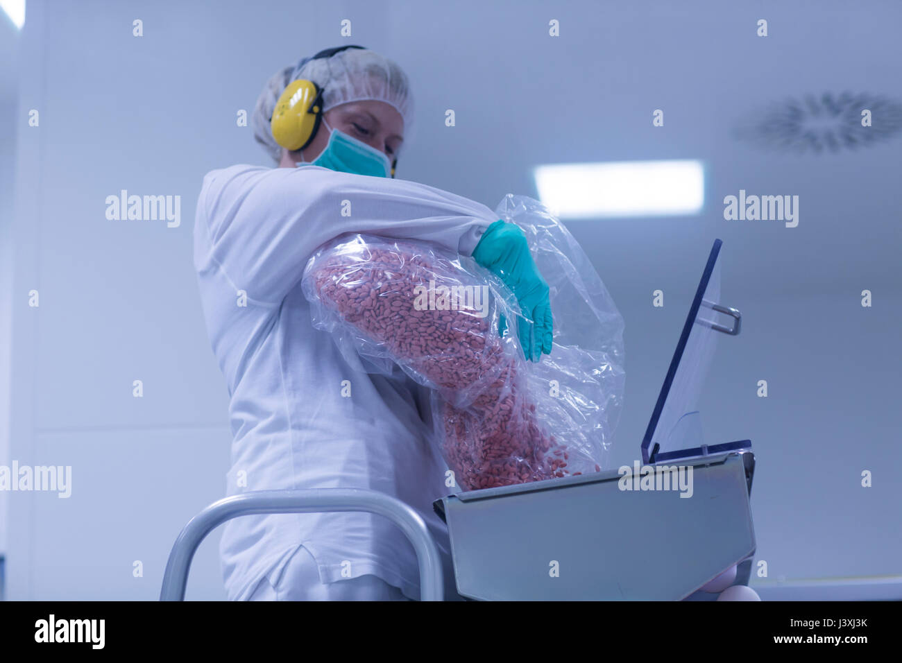 Arbeitnehmer gießen Tabletten in die Sortieranlage in pharmazeutischen Betrieb Stockfoto