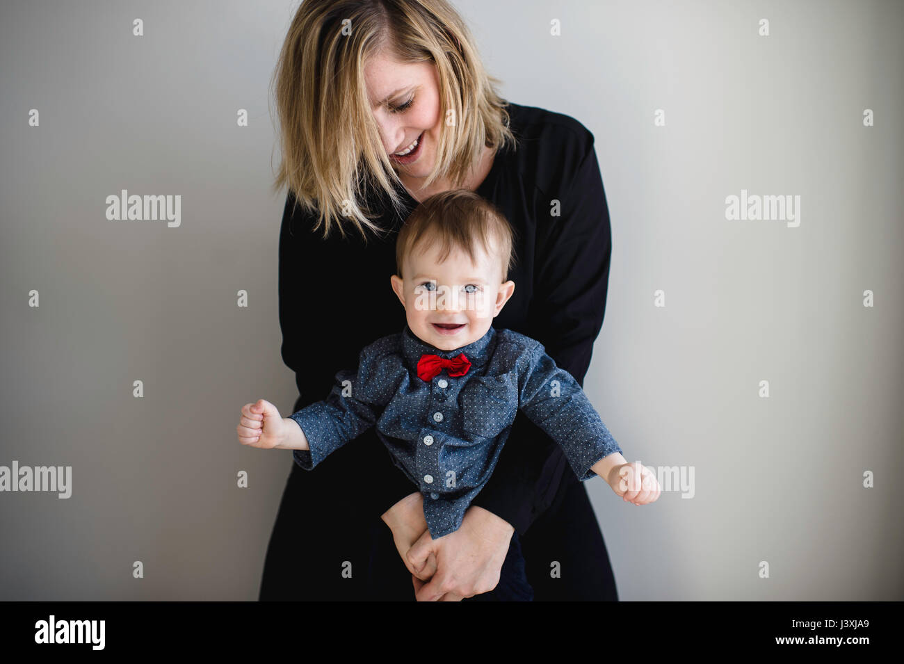 Portrait der männlichen Kleinkind in red Bow Tie von Mutter gehalten wird Stockfoto