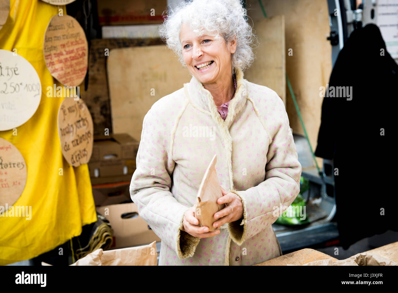 Reife weibliche stall Inhaber Verkauf von getrockneten Lebensmitteln an den lokalen französischen Markt Stockfoto
