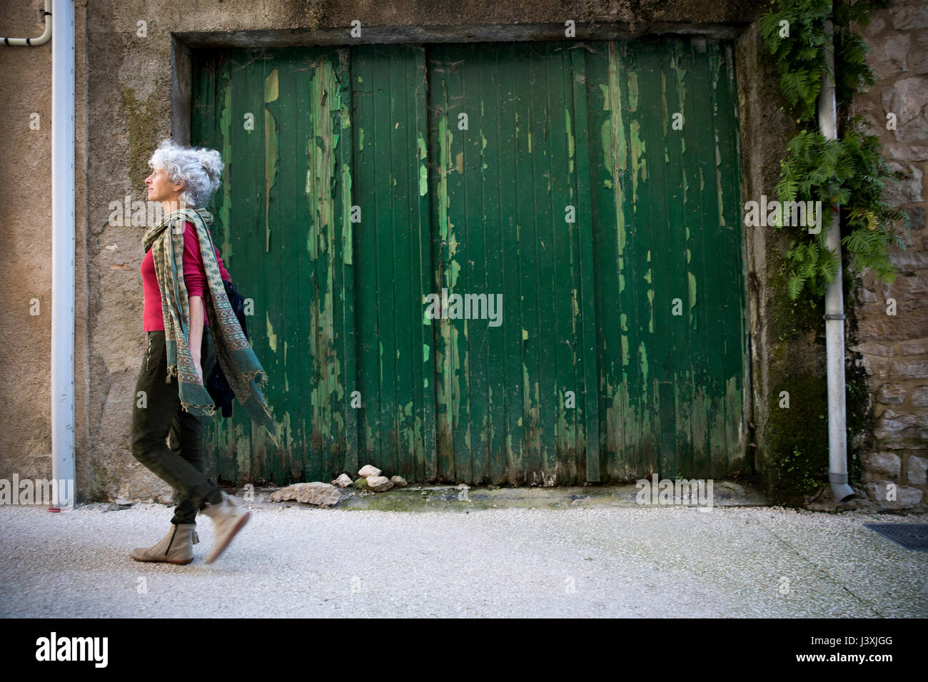 Seitenansicht der Frau zu Fuß in der Straße. Parcé-sur-Sarthe, Frankreich Stockfoto