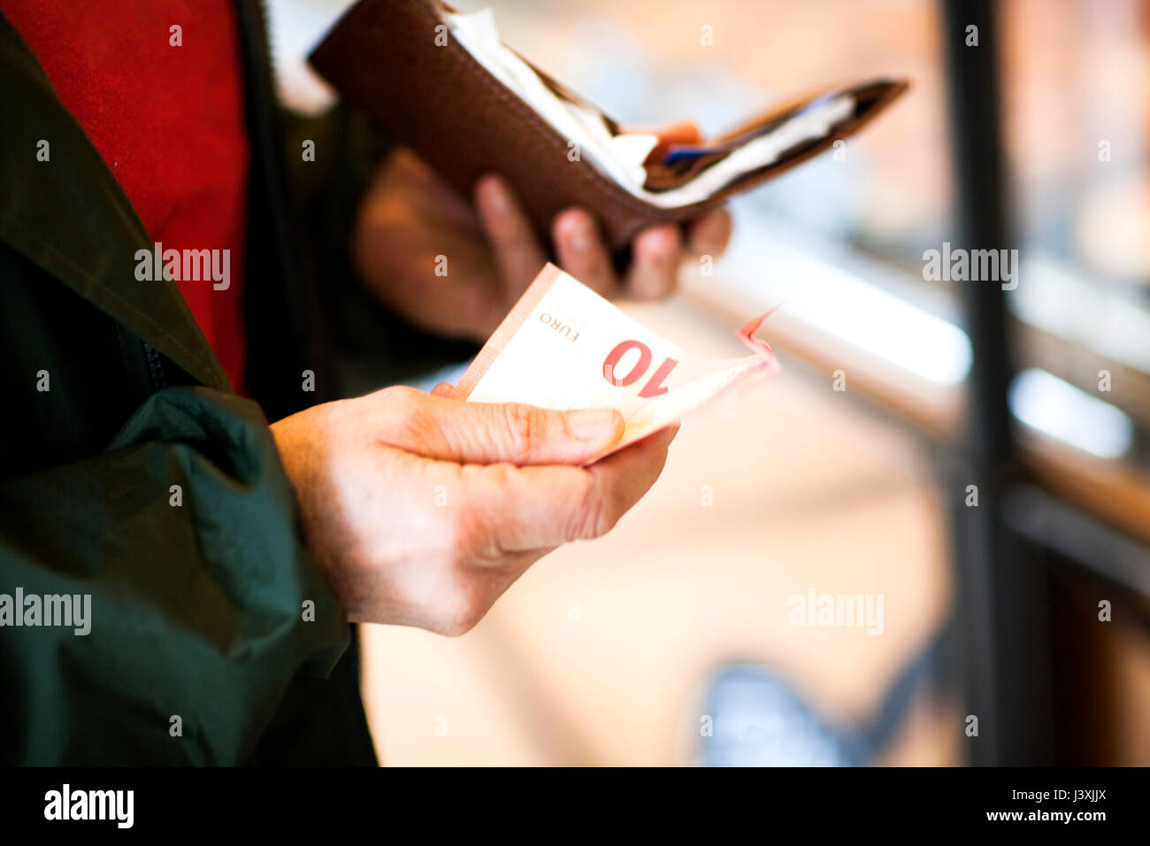 7/8-Ansicht von Frau mit einer Banknote und Geldbeutel Stockfoto