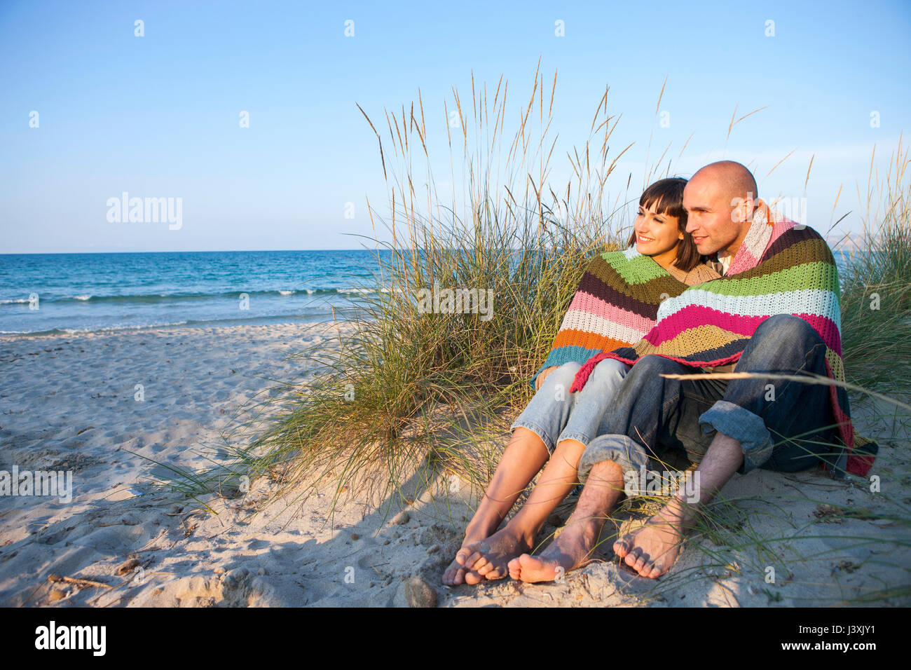 Paar mit Decke auf Sand dune, Mallorca, Spanien Stockfoto