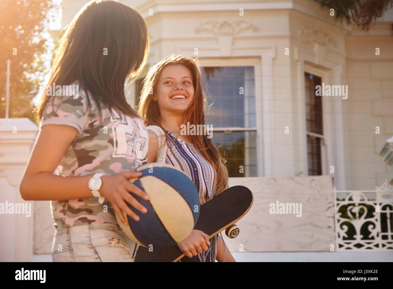 Mädchen im Teenageralter mit Kugel- und Skateboard in Street, Kapstadt, Südafrika Stockfoto