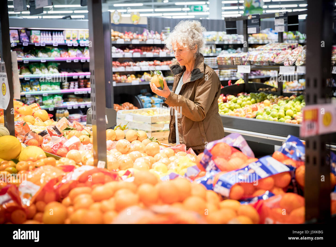 Reife Frau im Supermarkt, der frische Produkte Stockfoto