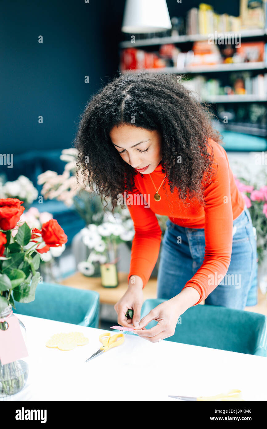 Weibliche florist Vorbereitung Labels für blumenarrangierens Workshop Stockfoto