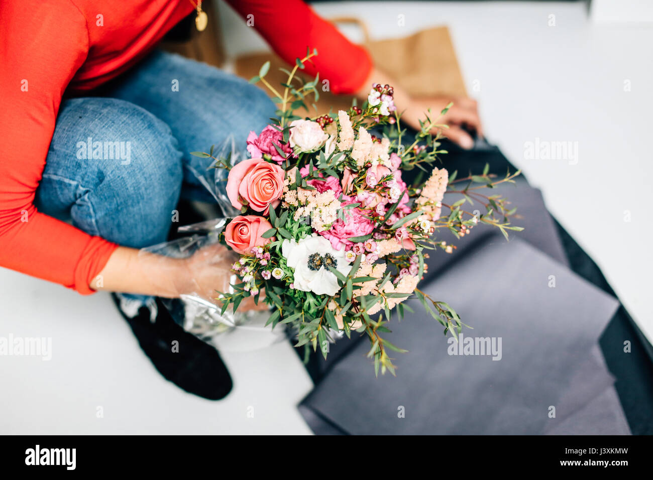 Hals nach unten an der weiblichen Florist umhüllen Blumenstrauß in Floristen Werkstatt Stockfoto