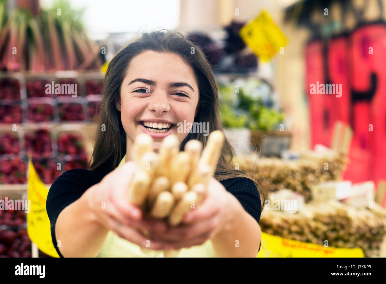 Porträt der jungen Frau stall Trader holding Bündel Grissini Stockfoto